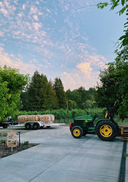 Bragg Vineyards tractor in the driveway with a flatbed of barrels